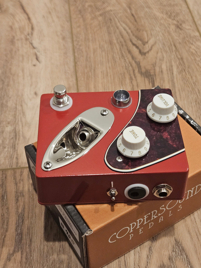 A CopperSound Strategy V2 Two Channel Preamp & Overdrive Dakota Red CUSTOM BUILD guitar preamp pedal with an overdrive mode sitting on top of a box.