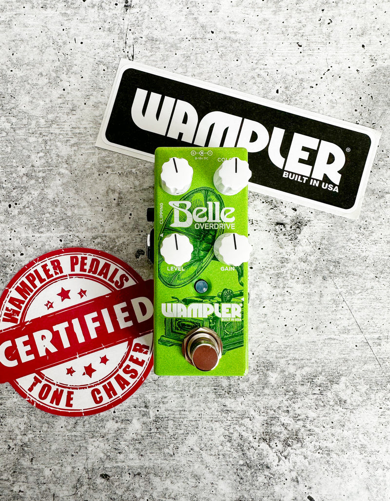A Wampler Belle Overdrive Pedal with a sticker next to it.