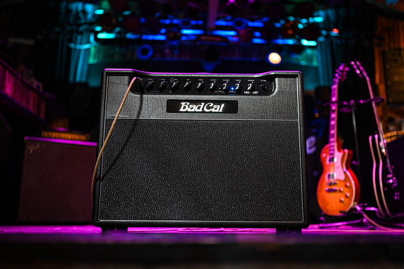 A Bad Cat amplifier, the Hot Cat 1x12 Combo 45W 2 Channel Amp, sitting on stage in front of a purple light, showcasing its gain and channel capabilities.