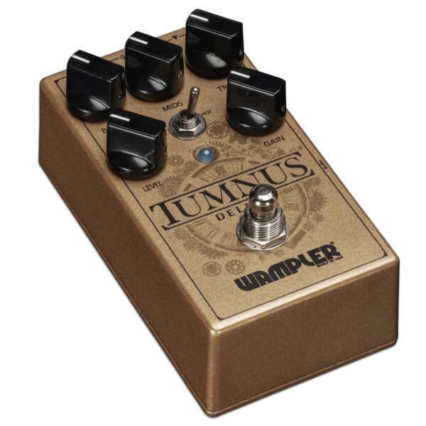 The Wampler Tumnus Deluxe Overdrive Boost, a gold pedal with four knobs on it, offers true bypass performance and tonal flexibility.