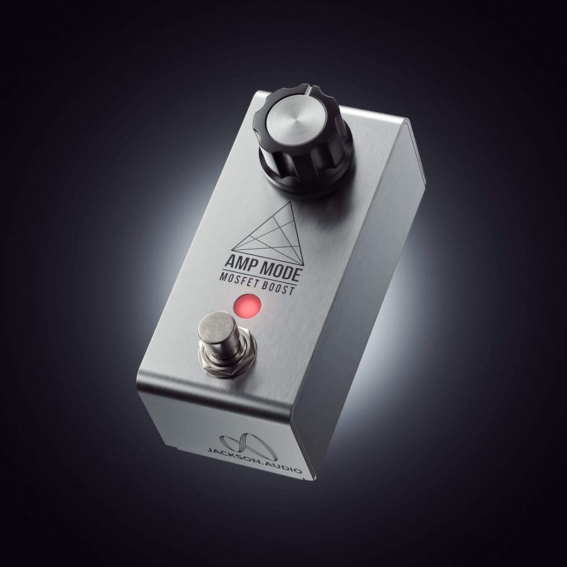 A Jackson Audio Amp Mode Boost Pedal, featuring a silver pedal with a red button on it, and designed with a MOSFET transistor boost for enhanced performance and an AMP MODE for optimal sound output.