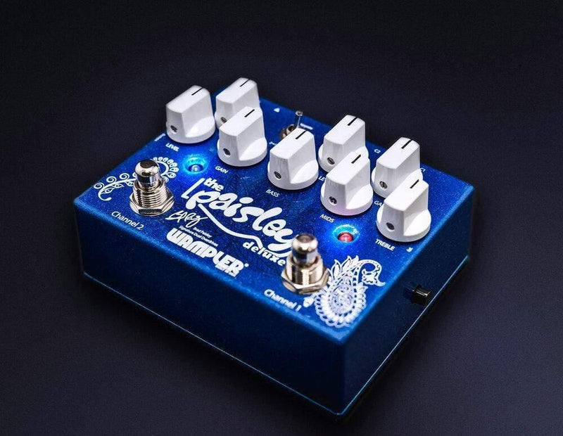 The Wampler Paisley Drive Deluxe Overdrive Distortion, a blue overdrive pedal, is equipped with four knobs.