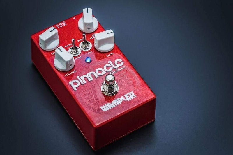 A red Wampler Pinnacle Distortion V2 pedal with two knobs on it, designed to deliver the Extreme gain and replicate the iconic Brown Sound.